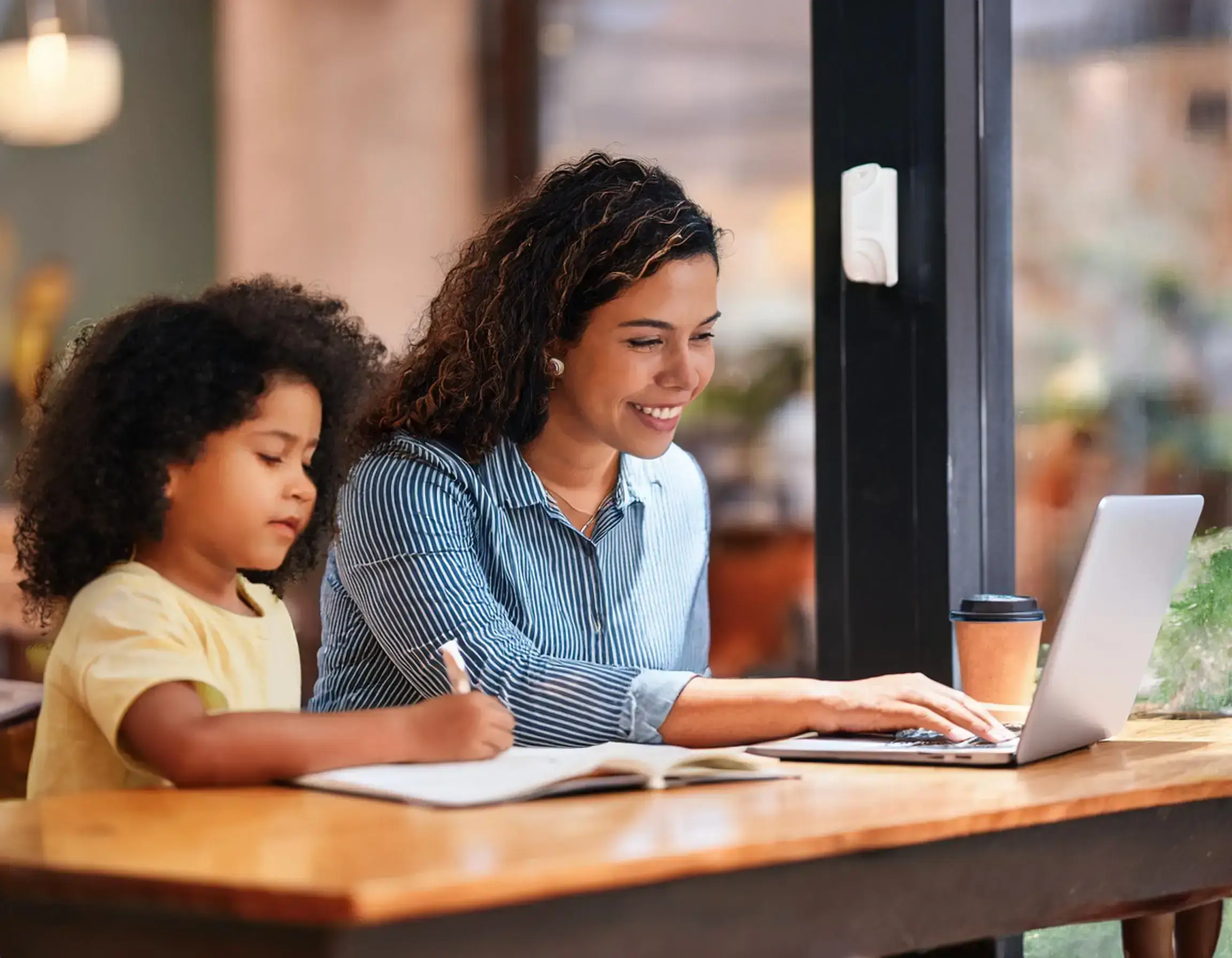 What is the tax credit for a child in 2025 Firefly A busy working mom checking her finances on a laptop at a coffee shop while her child does h 1 1